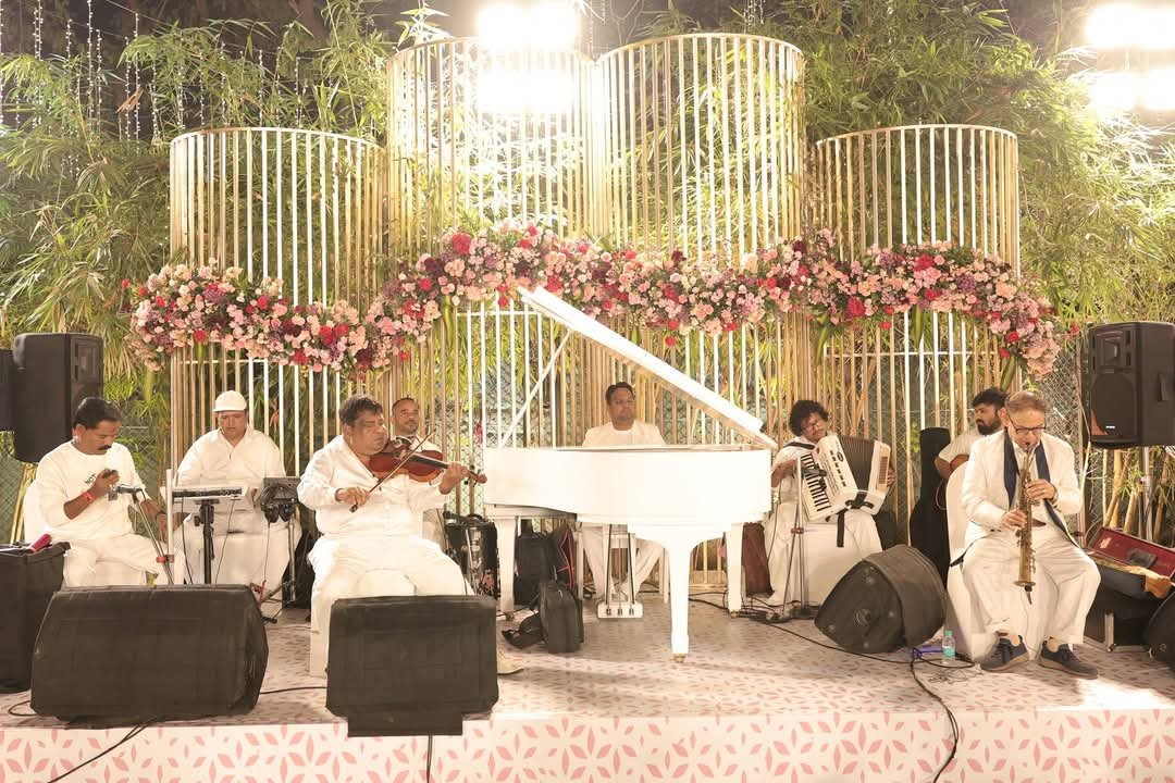 White theme band performing on a floral decorated stage